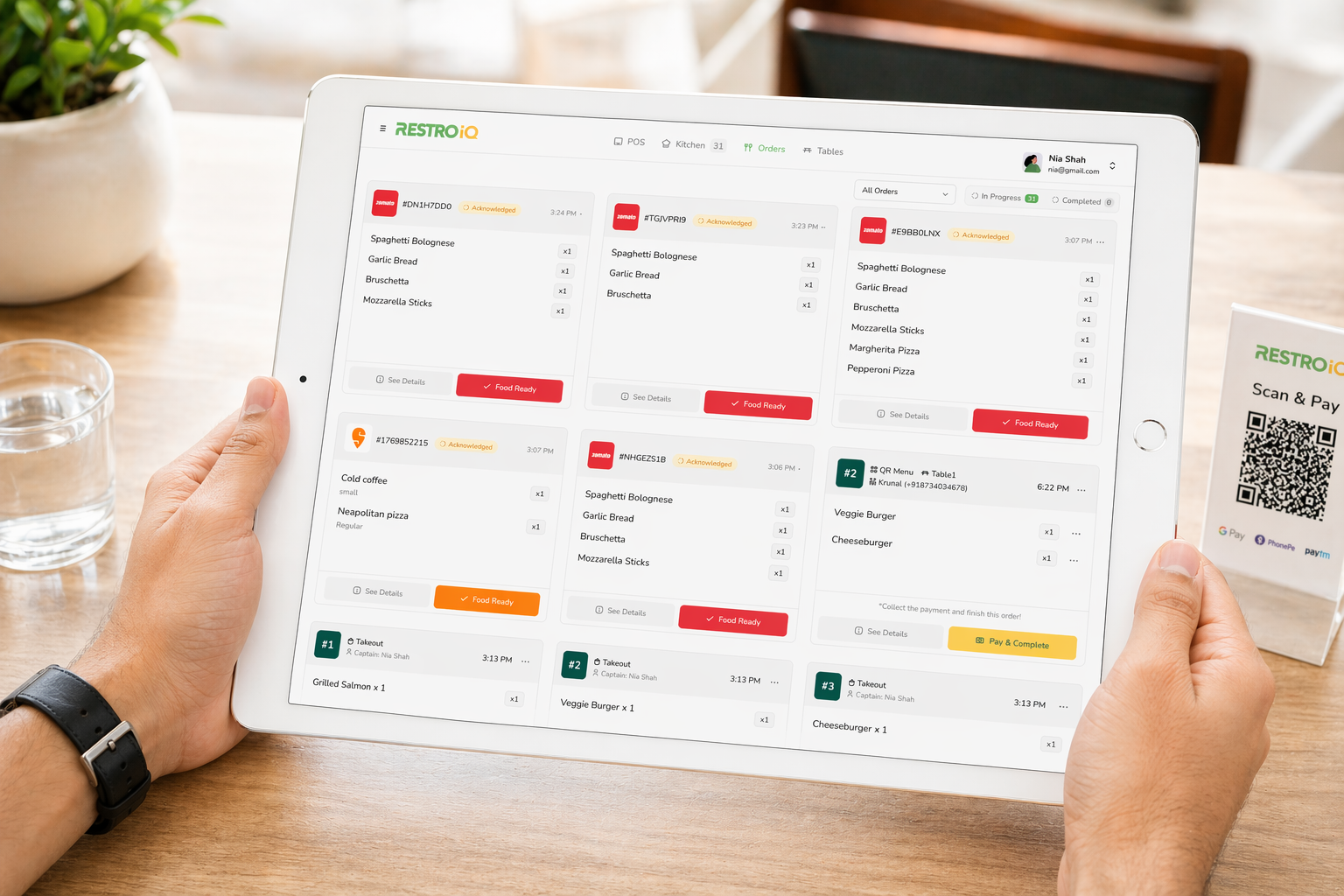 RestroIQ order management screen on a tablet showing live dine-in, takeaway and delivery orders