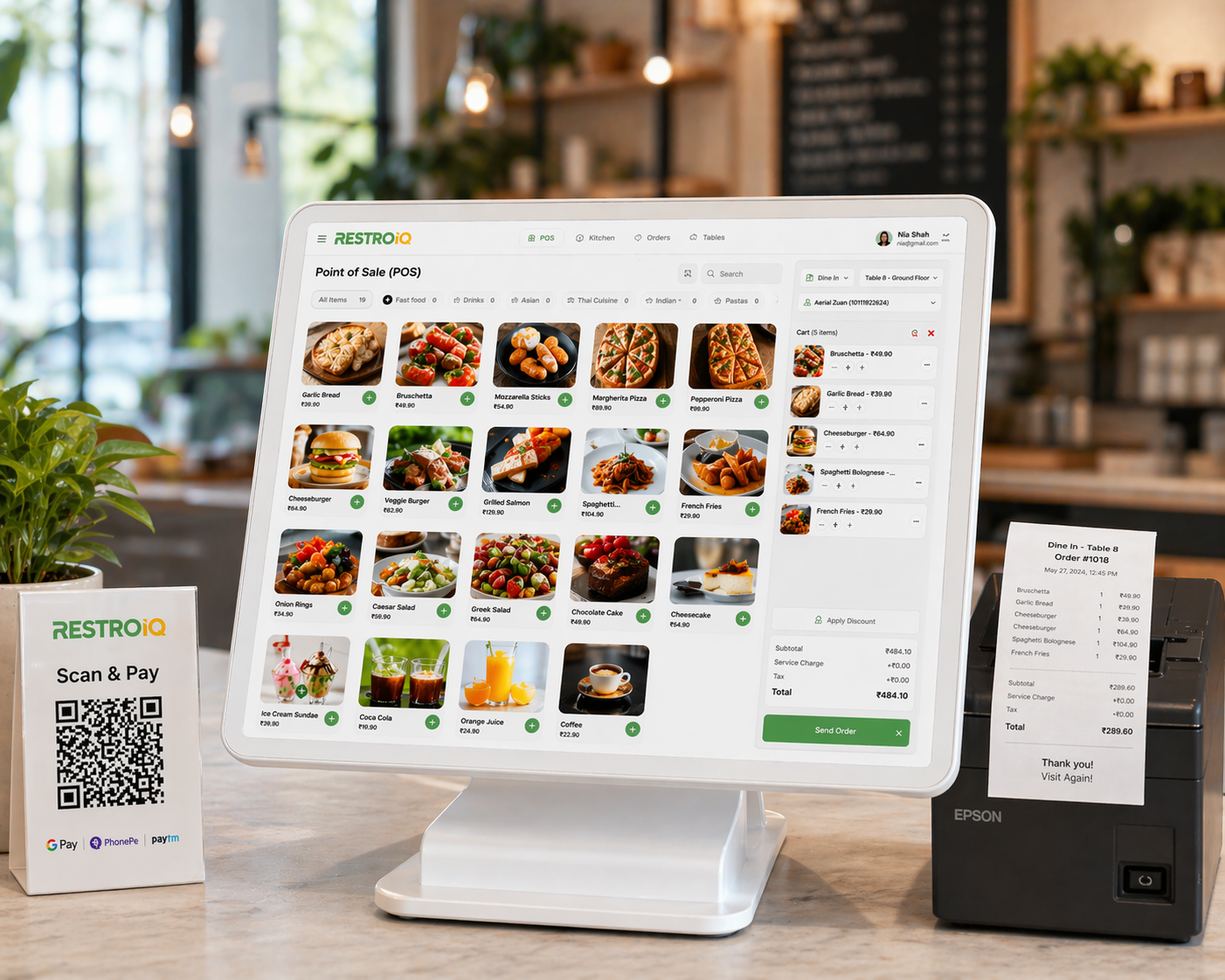 RestroIQ restaurant POS terminal on a counter with QR Scan and Pay and a thermal receipt printer